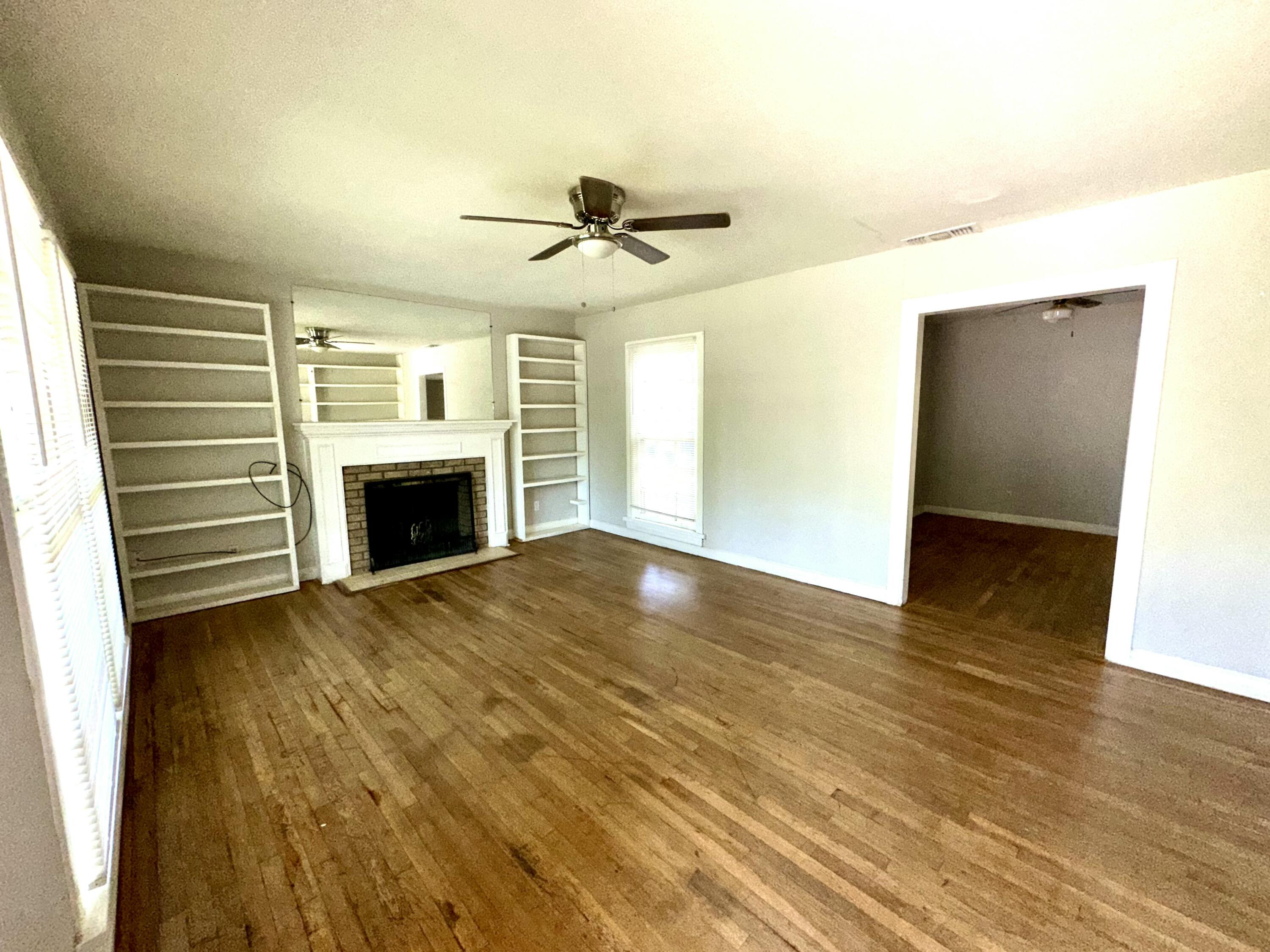 3012 22nd Street Lubbock, TX 79410 - Photo 2 of 11 a view of empty room with wooden floor and fireplace