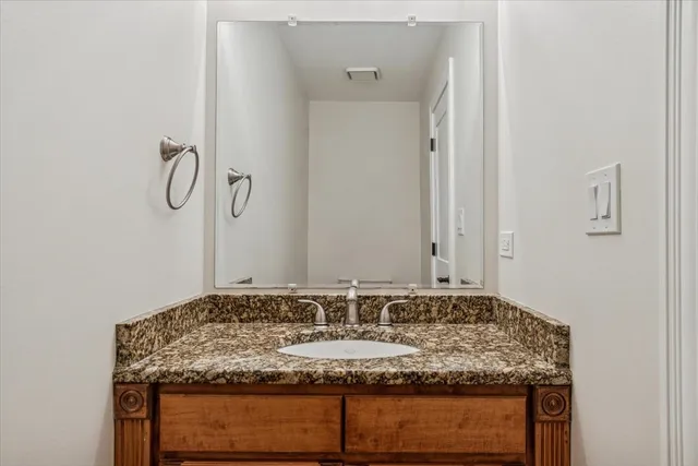 a bathroom with a granite countertop sink and a mirror