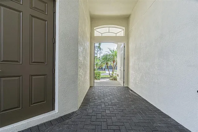 a view of a hallway with wooden floor and a window