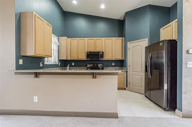 a kitchen with stainless steel appliances a refrigerator a sink a stove a microwave a sink and cabinets