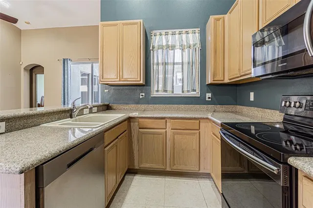 a kitchen with stainless steel appliances granite countertop a sink stove and cabinets