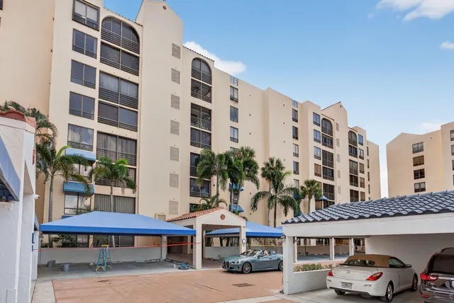 a front view of a building with glass windows and small yard