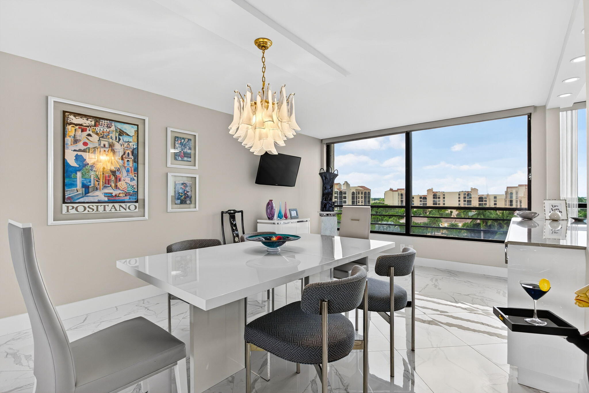 7186 Promenade Drive, Unit 701 Boca Raton, FL 33433 - Photo 11 of 39 a view of a dining room with furniture a chandelier and large windows