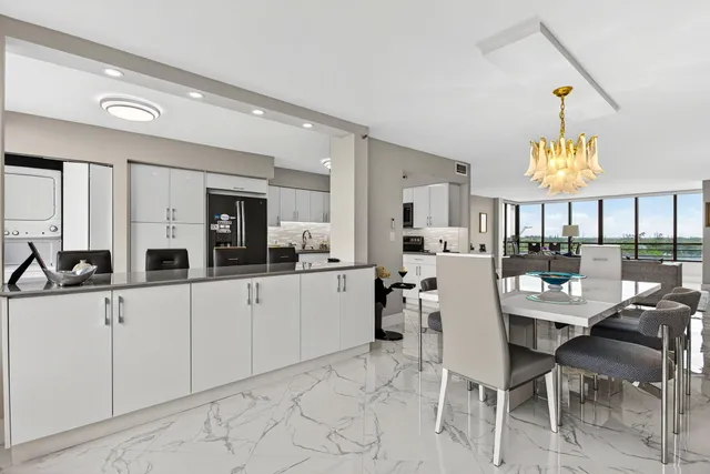 a kitchen with stainless steel appliances kitchen island granite countertop a table and chairs in it