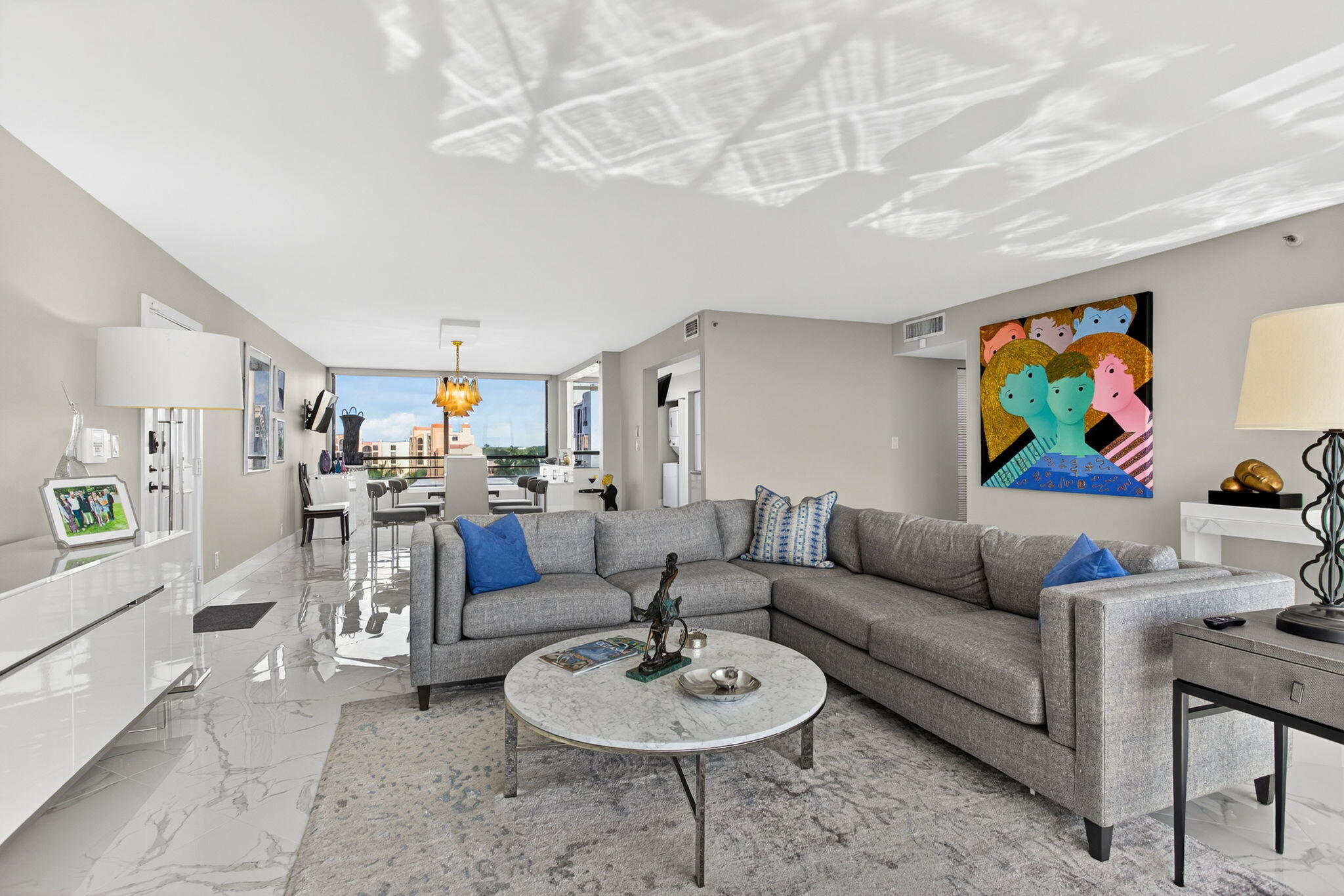 7186 Promenade Drive, Unit 701 Boca Raton, FL 33433 - Photo 4 of 39 a living room with furniture and a dining table with kitchen view