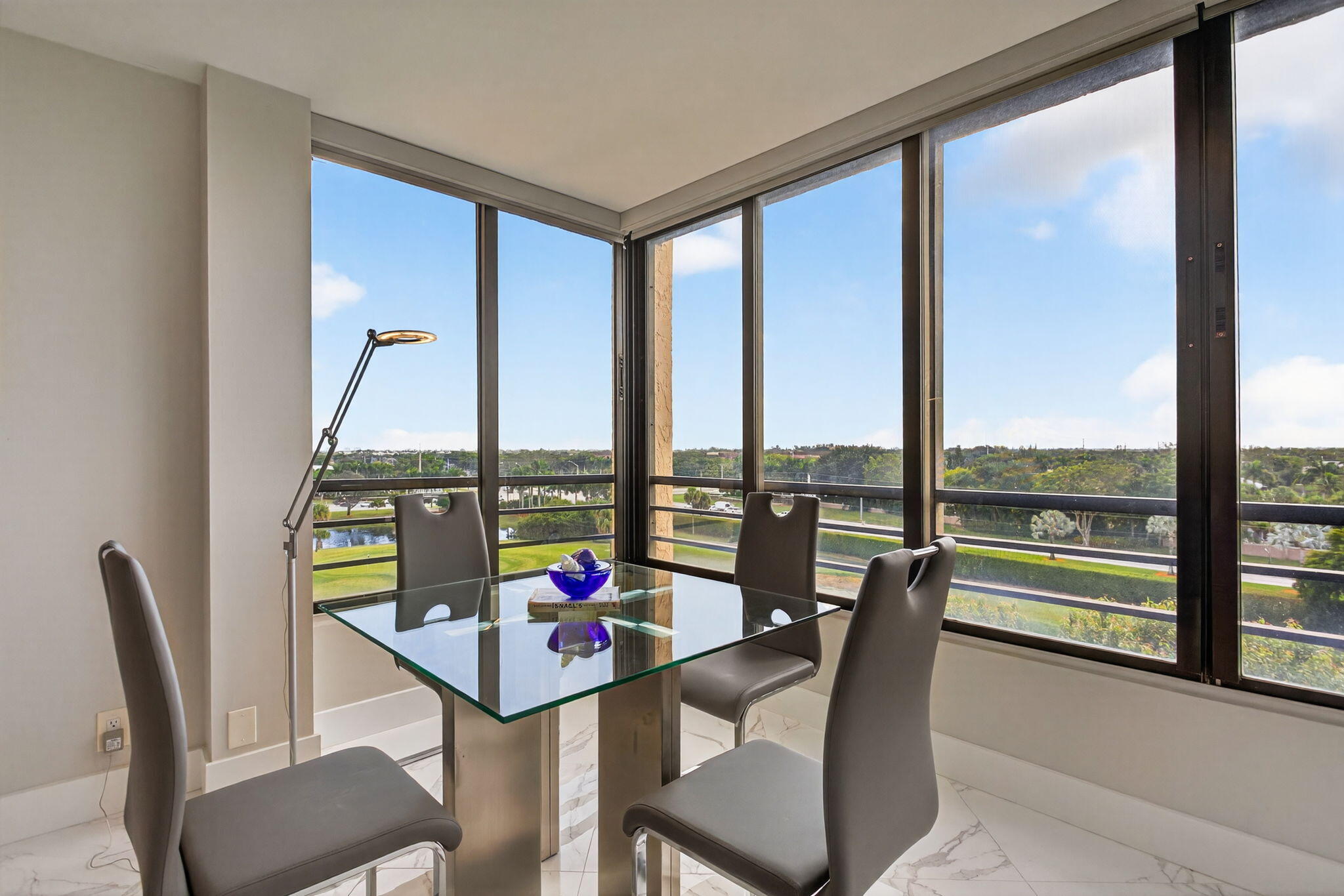 7186 Promenade Drive, Unit 701 Boca Raton, FL 33433 - Photo 9 of 39 a view of a city from a dining room with large windows and furniture