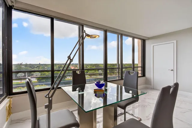 a view of a living room with furniture and floor to ceiling windows