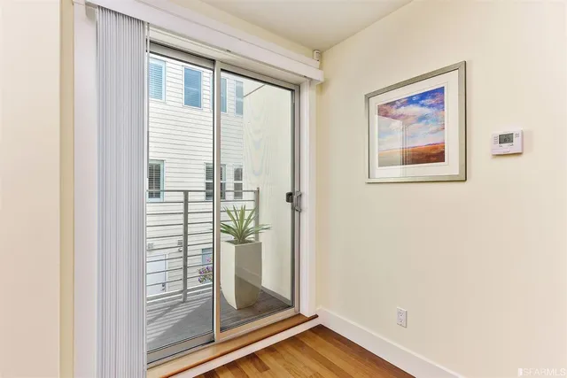 a view of a bedroom with wooden floor and front door
