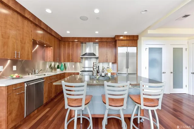 a kitchen with a dining table chairs and wooden floor