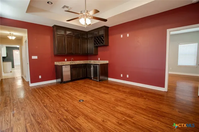 a view of kitchen with stainless steel appliances granite countertop cabinets and wooden floor