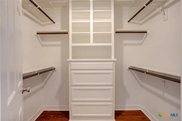 a view of walk in closet with empty racks