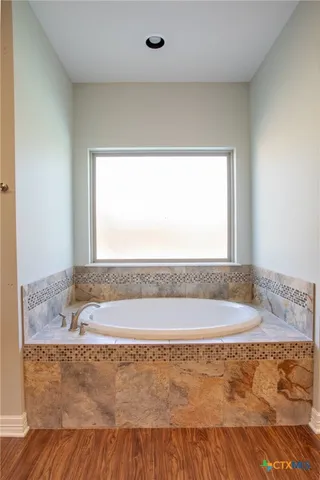 a bath tub sitting in a bathroom next to a window