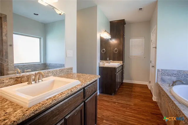 a spacious bathroom with a sink double vanity granite and a mirror