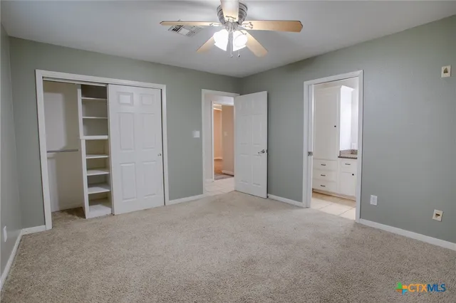 an empty room with a cabinet and a ceiling fan