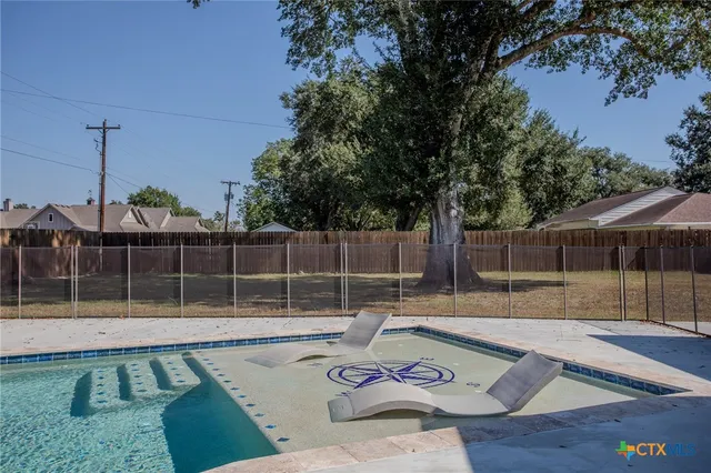 a view of a backyard with swimming pool