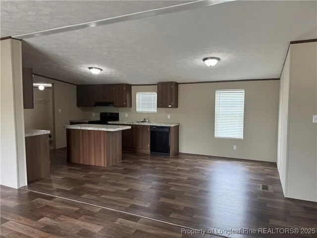 a kitchen with stainless steel appliances kitchen island granite countertop a stove a sink and a refrigerator