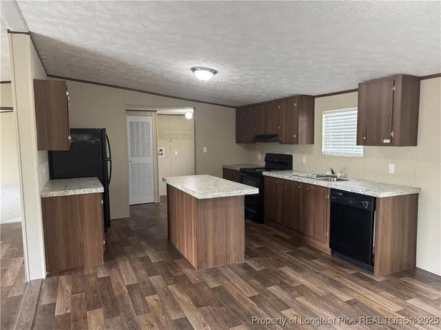 a kitchen with a sink and a stove top oven