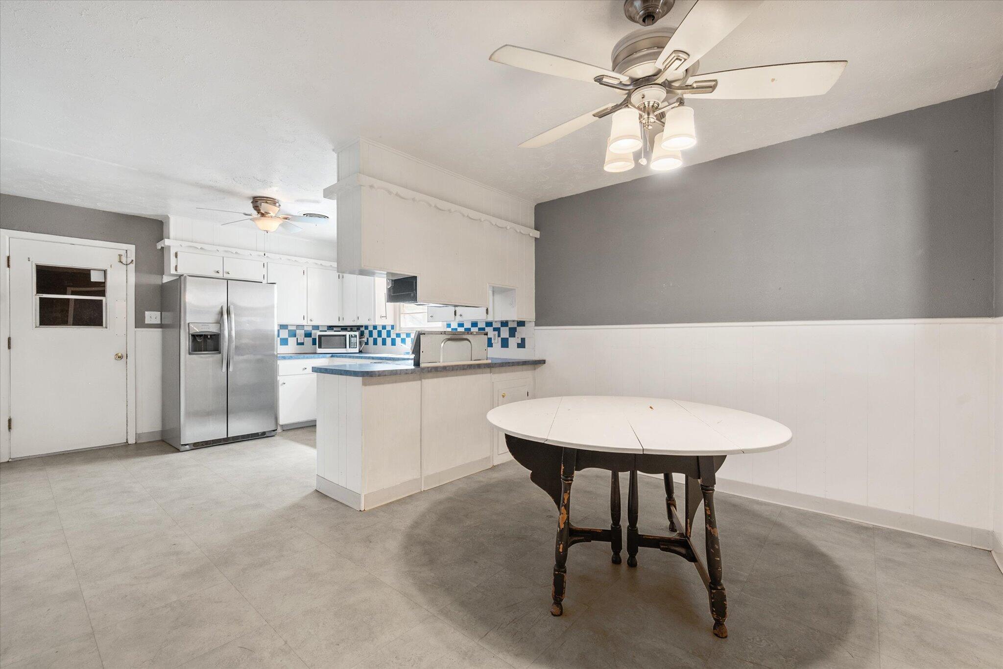 4604 27th Street Lubbock, TX 79410 - Photo 22 of 36 a kitchen with stainless steel appliances a white table chairs and a refrigerator