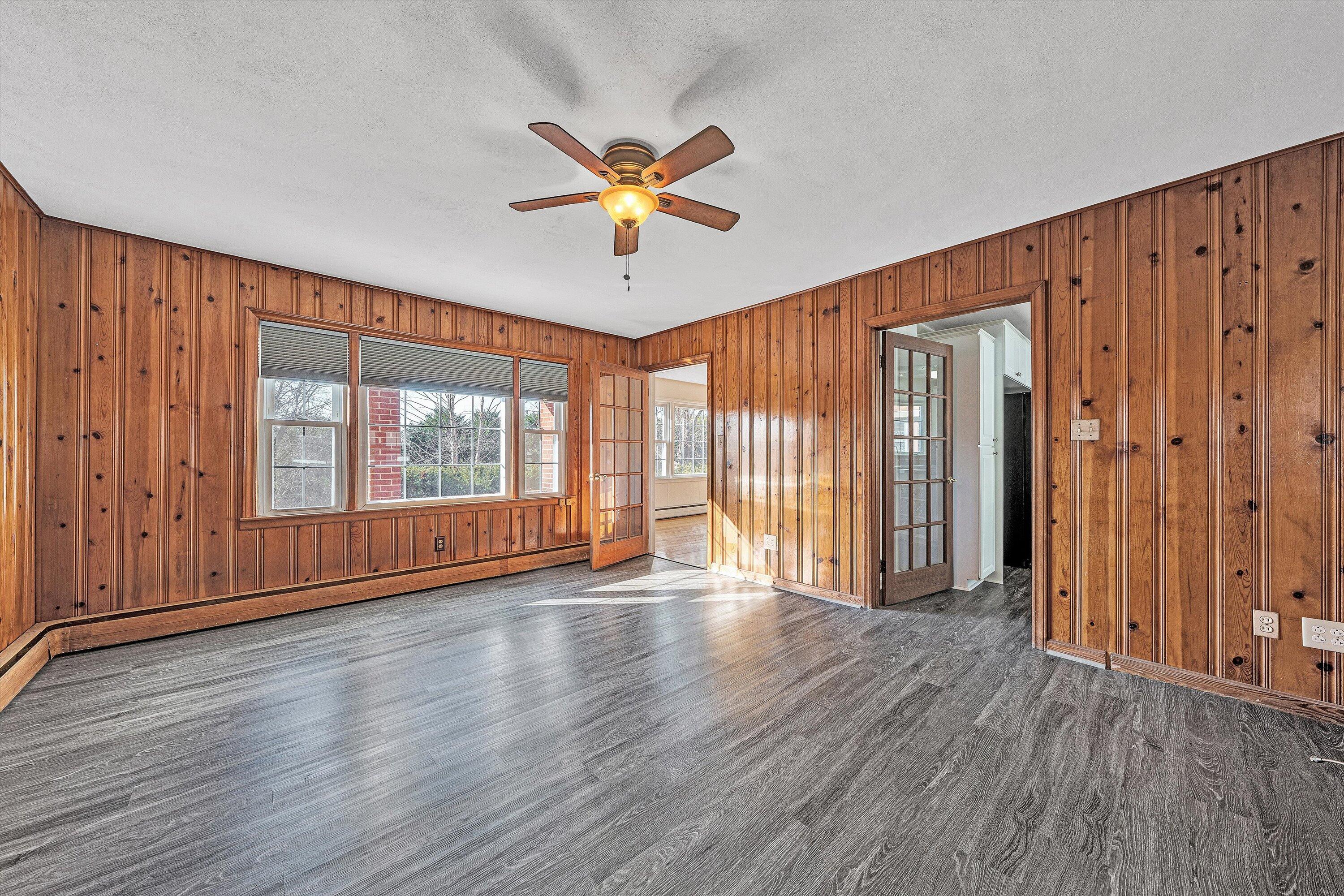 1944 Blue Ridge Springs Road Blue Ridge, VA 24064 - Photo 13 of 60 an empty room with wooden floor and windows with curtains