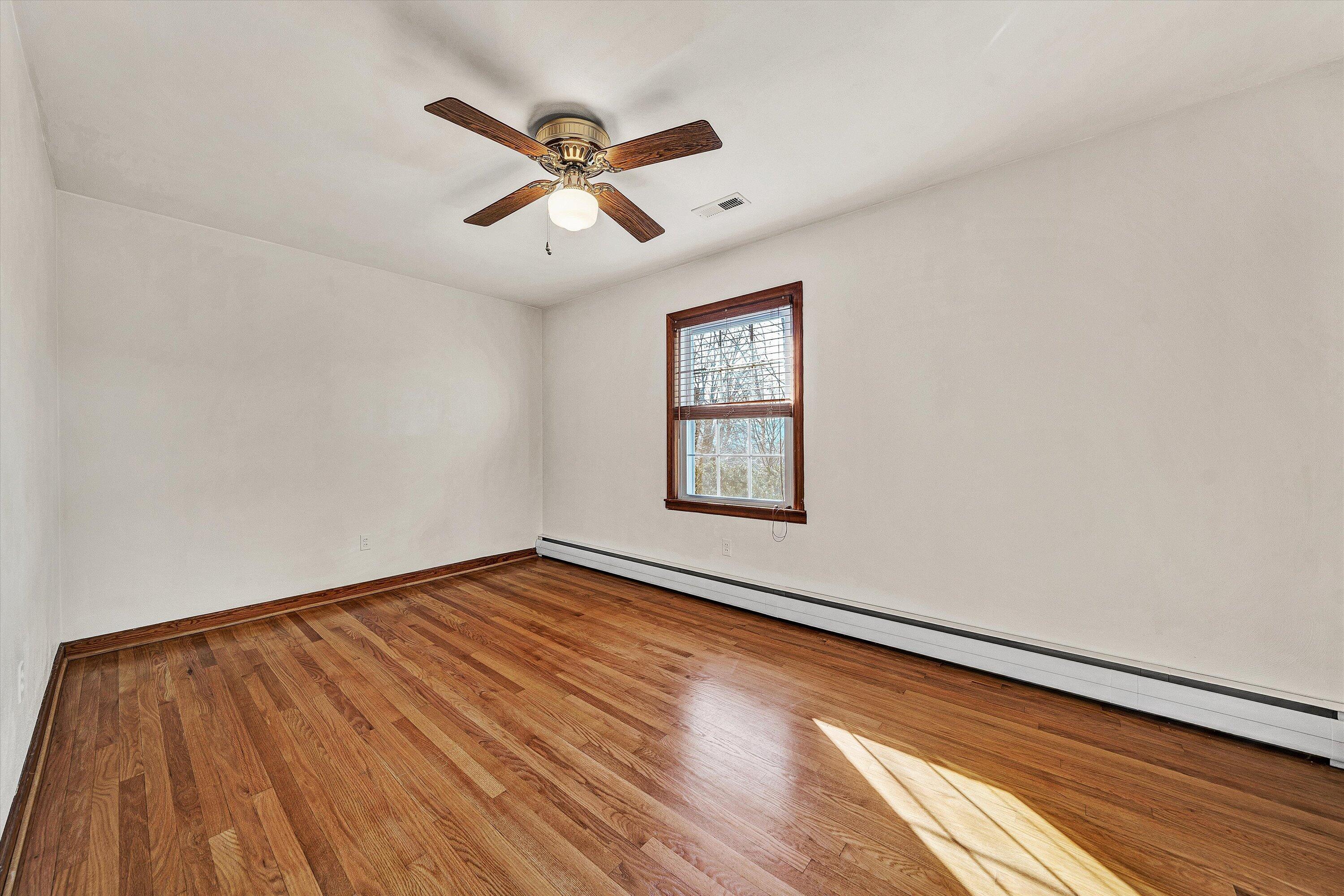 1944 Blue Ridge Springs Road Blue Ridge, VA 24064 - Photo 23 of 60 an empty room with wooden floor fan and windows