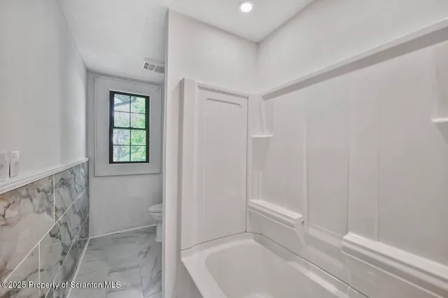 a bathroom with a sink mirror and toilet