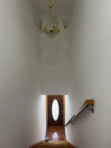 a view of a room with a hanging light and mirror