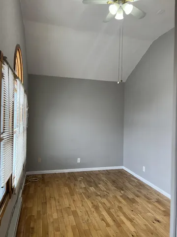 en empty room with window and chandelier fan