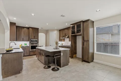 a spacious bathroom with a granite countertop sink a mirror and a bathtub