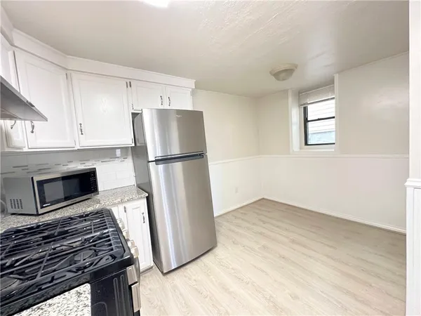 a kitchen with a refrigerator and a stove top oven
