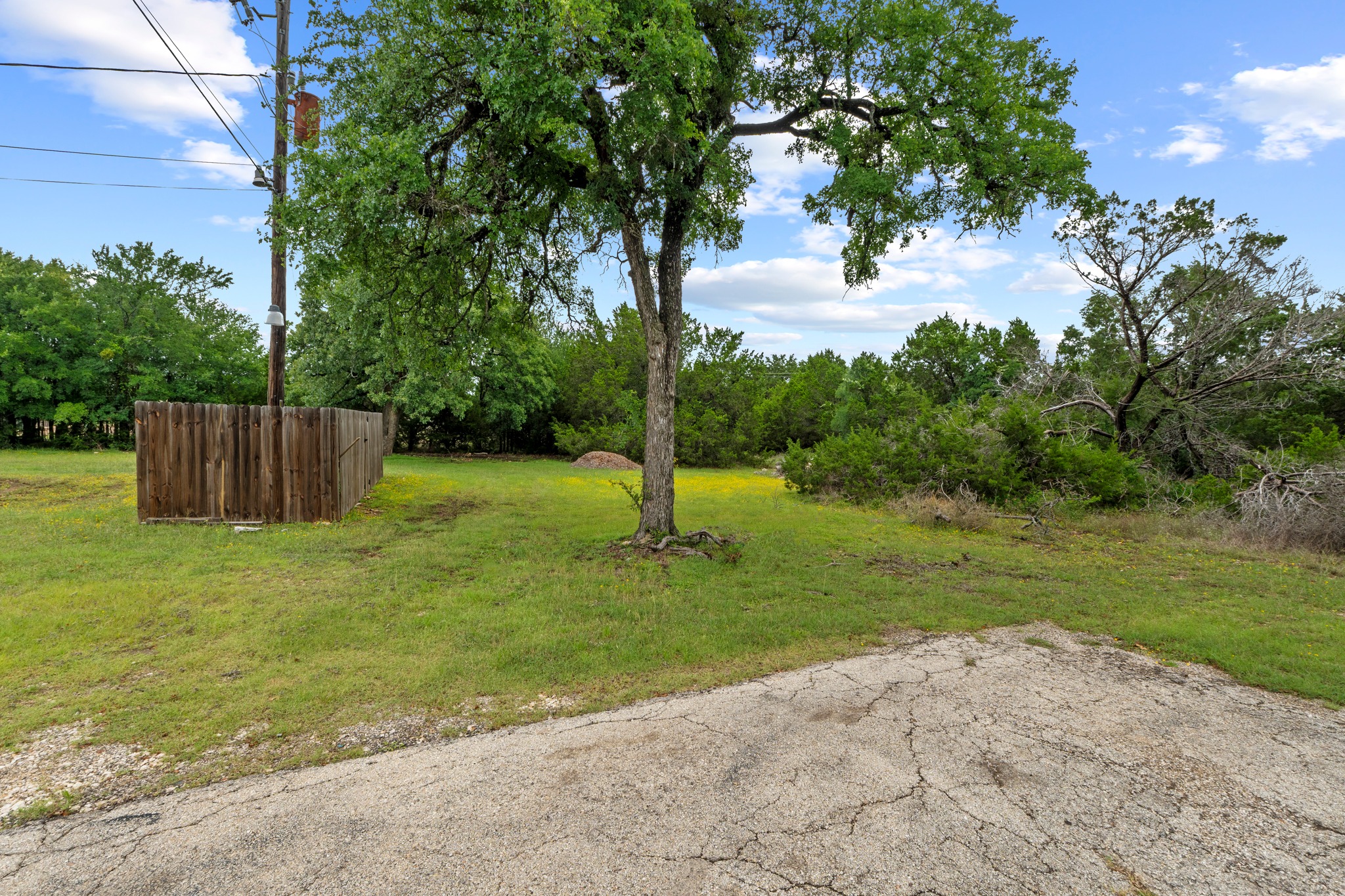 205 Sedro Trail Georgetown, TX 78633 - Photo 9 of 32 Mature trees and a partial privacy fence delineate this expansive lot, ready for your vision.