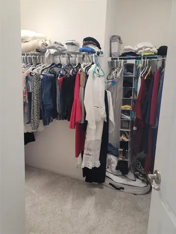 a view of walk in closet with clothes