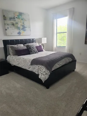 a bed sitting in a bedroom next to a window