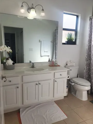a bathroom with a granite countertop toilet sink and mirror