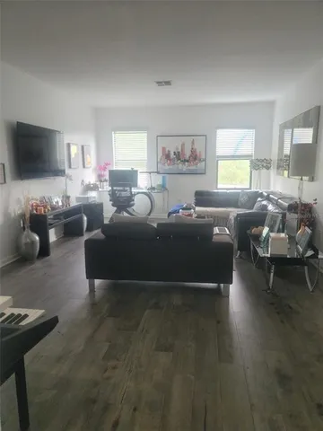 a living room with furniture wooden floor and a flat screen tv