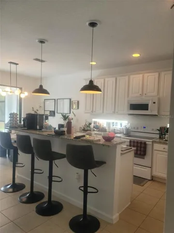 a kitchen with kitchen island granite countertop a table and chairs in it