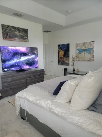 a bedroom with a bed and a painting on the wall