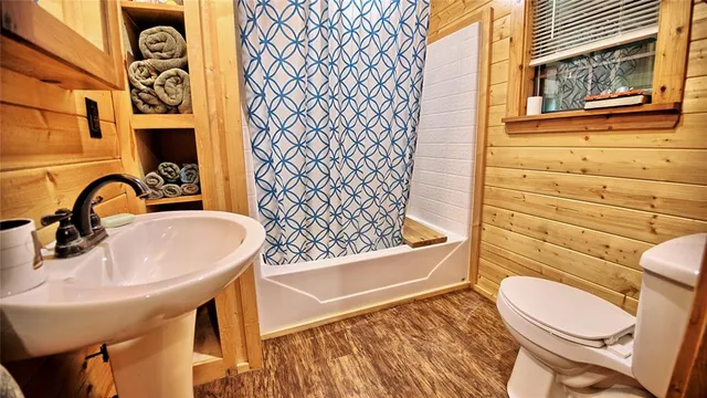 a bathroom with a sink a toilet and shower curtain