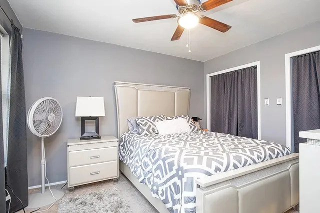 a bedroom with a large bed and a chandelier