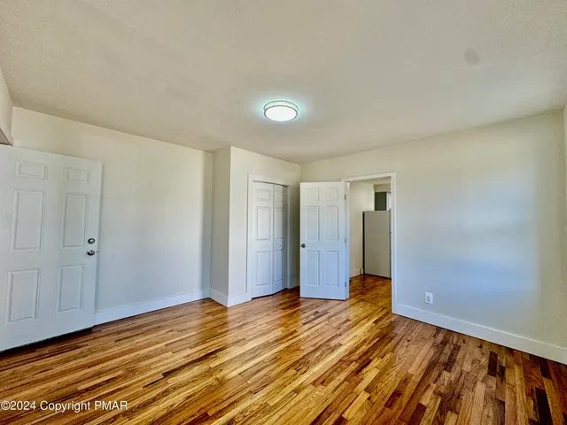a view of a room with wooden floor and bathroom