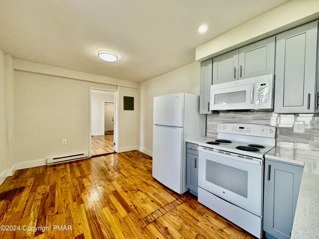 a kitchen with a stove a refrigerator and a microwave