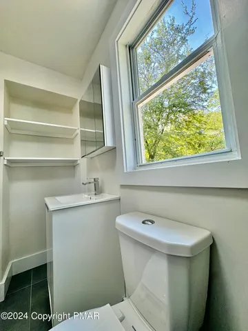a bathroom with a sink a toilet and a window