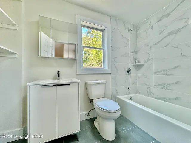 a white toilet sitting next to a bathroom sink