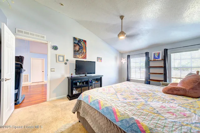 a bedroom with a bed and a flat screen tv