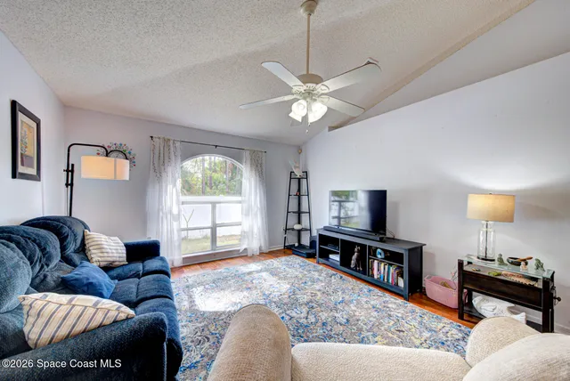 a living room with furniture a window and a flat screen tv