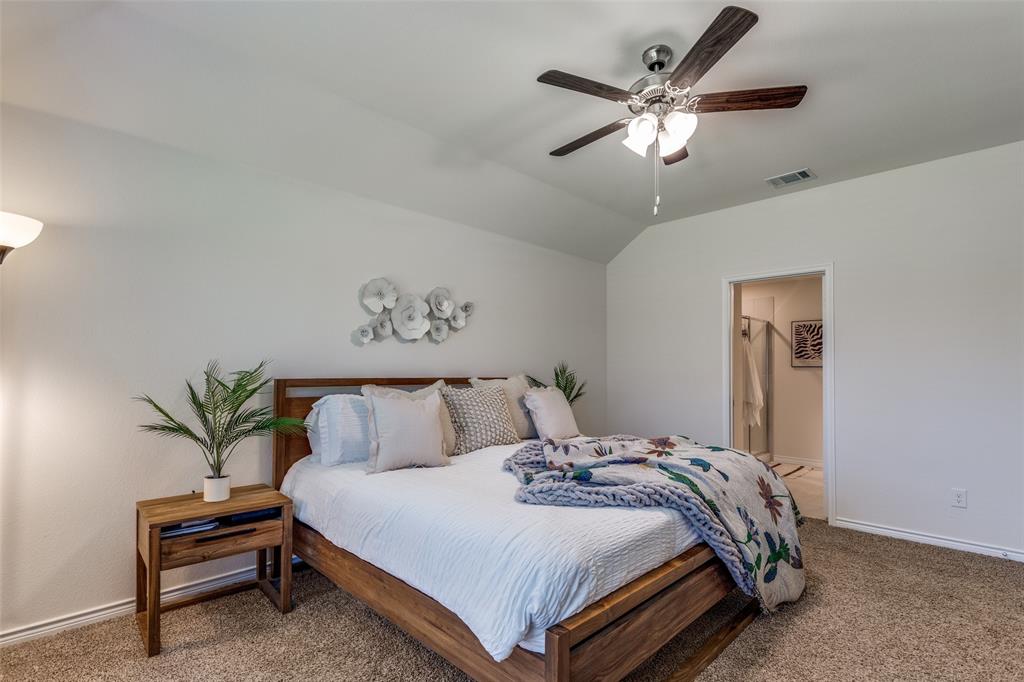 708 Cool Cyn Trail Princeton, TX 75407 - Photo 20 of 28 a bedroom with bed and a chandelier