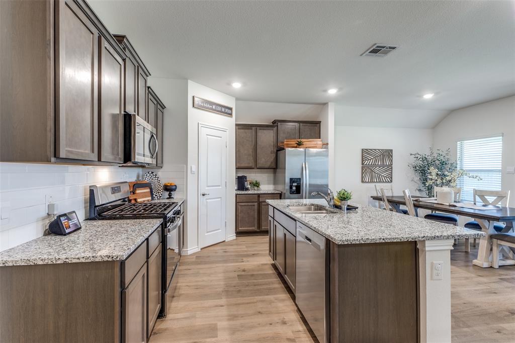 708 Cool Cyn Trail Princeton, TX 75407 - Photo 9 of 28 a kitchen with stainless steel appliances granite countertop a sink stove and refrigerator