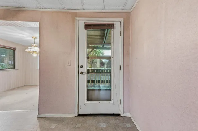 a view of a hallway with white walls and stairs