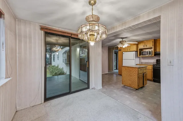 a view of a kitchen with refrigerator and windows
