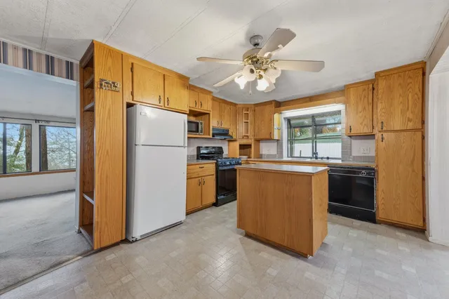 a kitchen with refrigerator a stove a sink dishwasher and cabinets