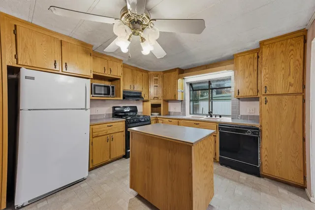 a kitchen with stainless steel appliances granite countertop a refrigerator a stove a sink a oven with a dining table and chairs